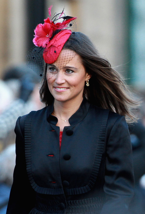 Pippa Middleton đội một chiếc mũ màu đỏ với mạng che mặt, cô kết hợp cùng trang phục tông màu đen.